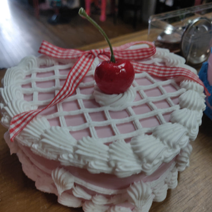 White icing with lattice bow and one cherry